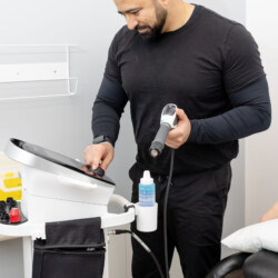therapist adjusting shockwave machine in mississauga