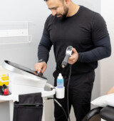 therapist adjusting shockwave machine in mississauga
