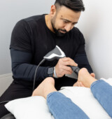 therapist performing foot shockwave therapy in mississauga